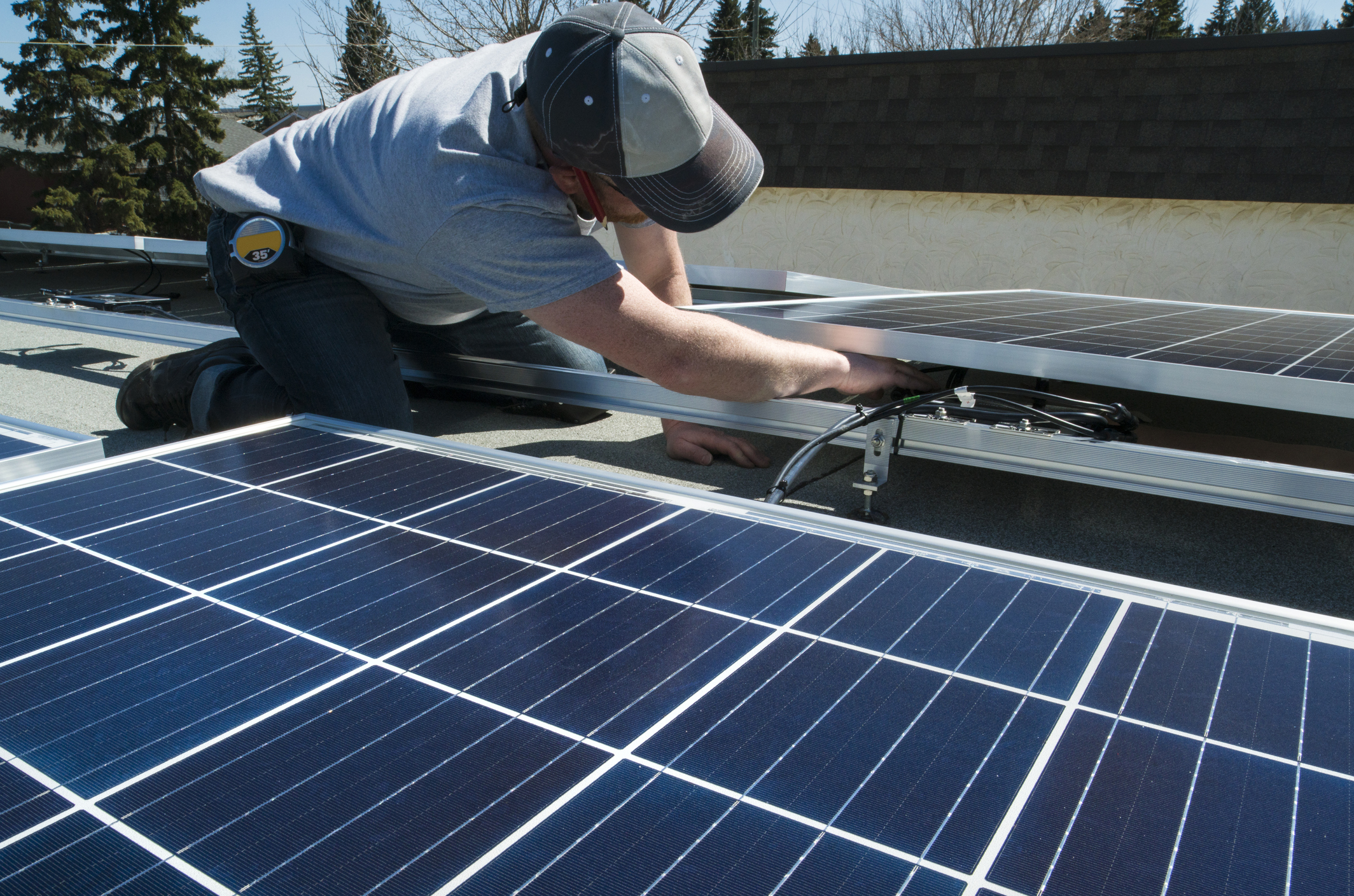 Werknemer zonnepanelen op plat dak installeert Energreen